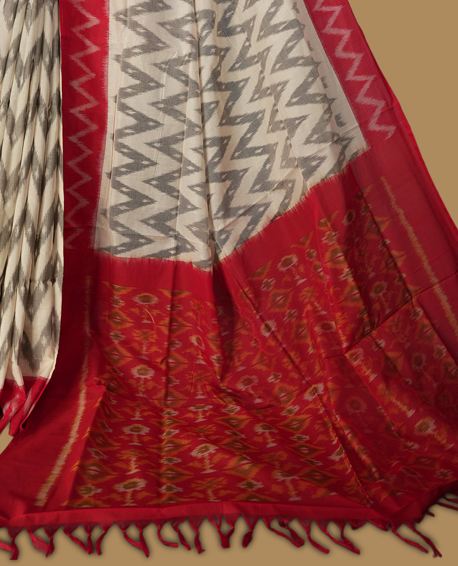 Off white colour Ikkat Pochampally saree with bold grey colour zigzag motifs and contrasting maroon borders, The striking woven pallu enhances its elegance, making it a perfect blend of tradition and style, Paired with a matching blouse.