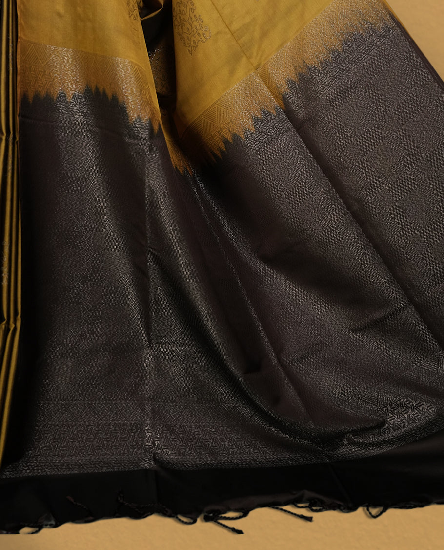 Dark mustard colour semi soft silk saree, adorned with subtle self woven motifs on the body & The design is elevated with an elegant zari border and dark chocolate colour pallu, paired with a matching blouse.