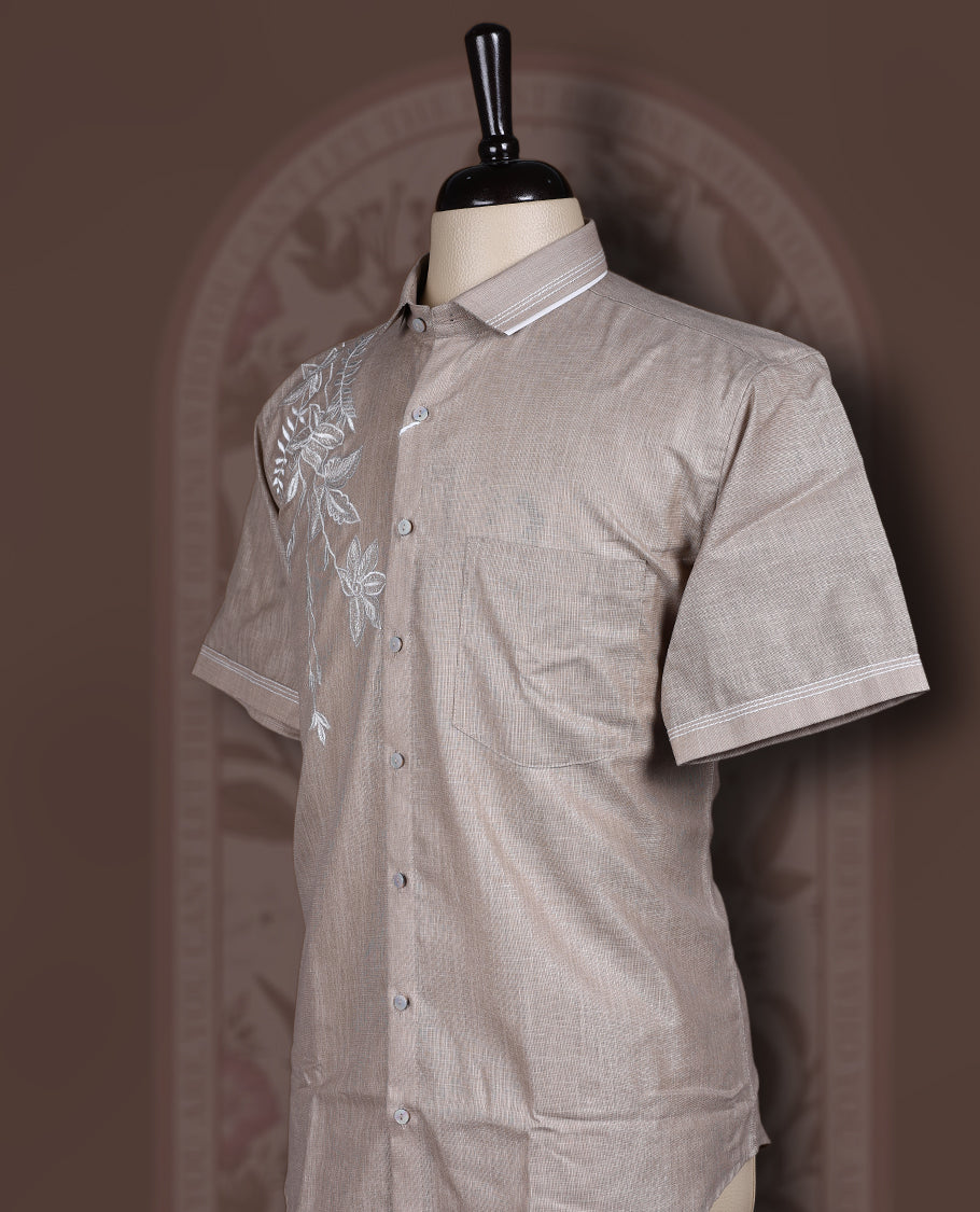 Taupe colour cotton linen short sleeve shirt featuring delicate white floral embroidery on the shoulder, Designed with a classic collar and button down front, offering a stylish blend of comfort and elegance.
