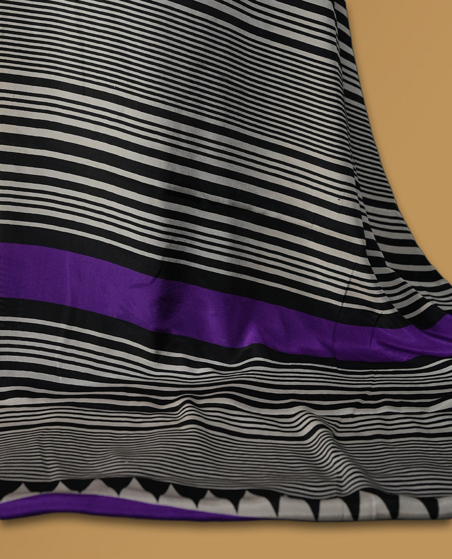Cream colour saree with bold black polka dots and striped patterns, highlighted by a vibrant purple border & Comes with a stylish matching blouse.