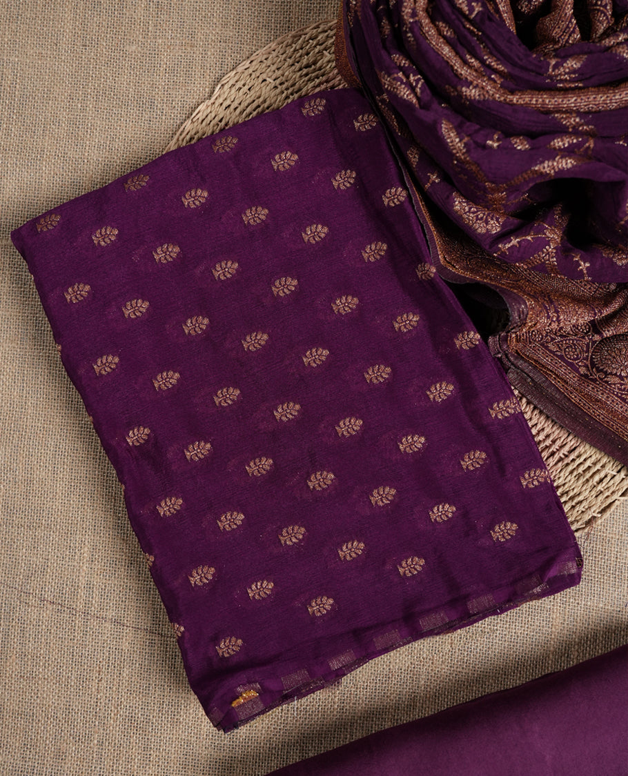 Grape colour suit material adorned with delicate golden motis & zari work & Comes with a beautifully woven dupatta and matching plain bottom fabric.