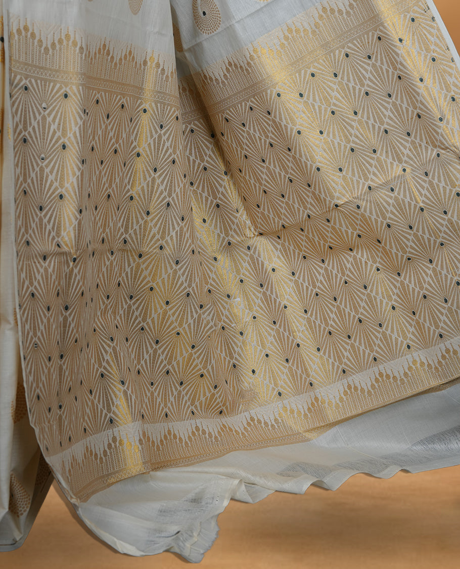 Off white Cotton Kerala saree featuring circular zari motifs, complemented by a rich geometric zari border and traditional pallu, paired with a matching blouse.