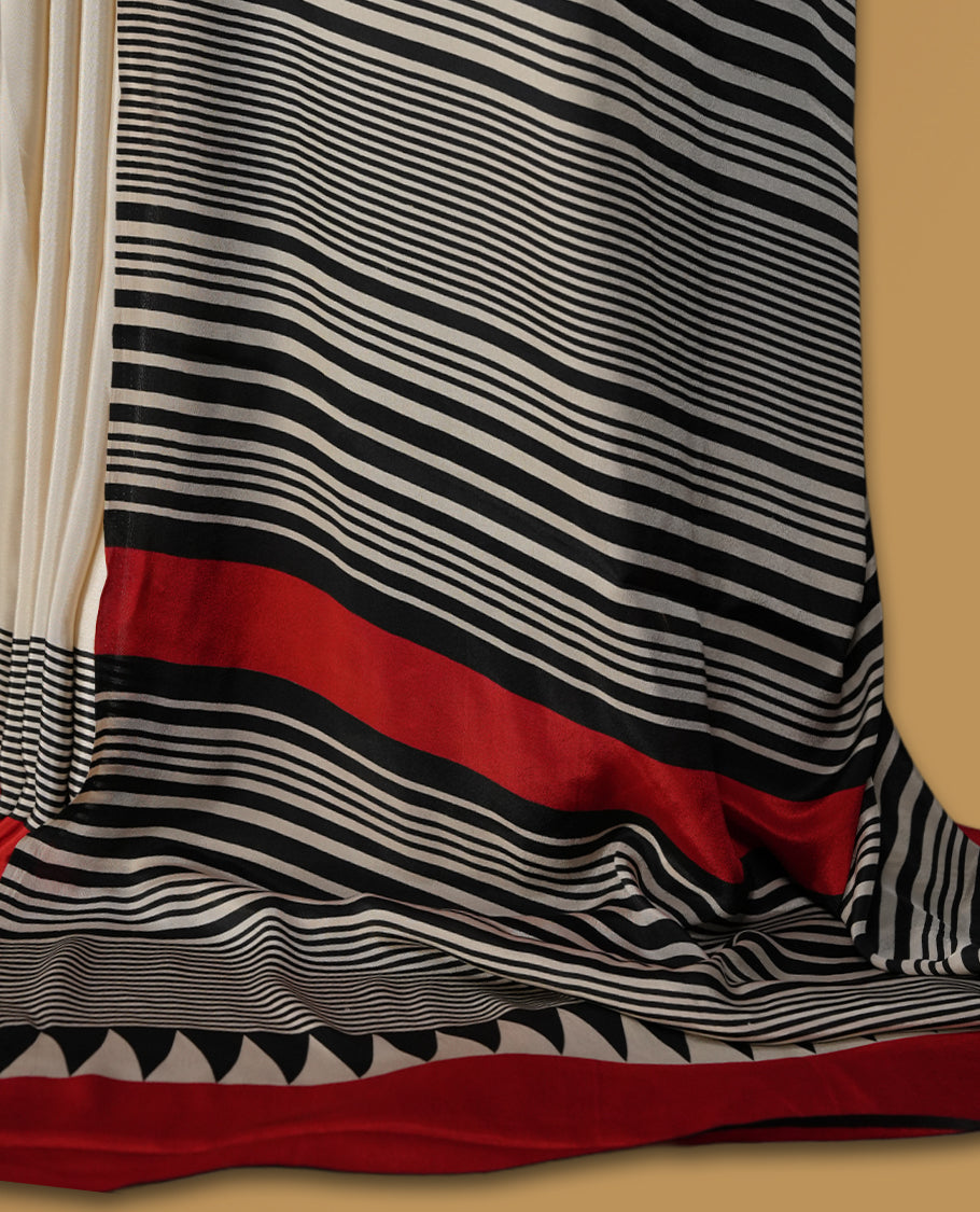 Cream colour saree with bold black polka dots, striped detailing, and striking red border & Comes with a stylish matching blouse.