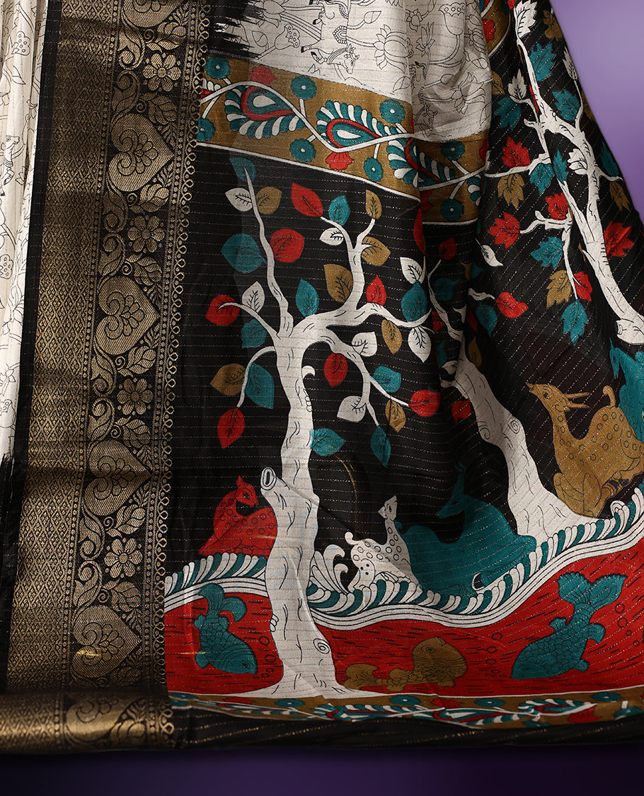 White colour saree adorned with intricate floral patterns across the body, enhanced by a rich black and gold zari border, featuring a vibrant artistic pallu with tree and nature motifs, paired with a matching blouse.