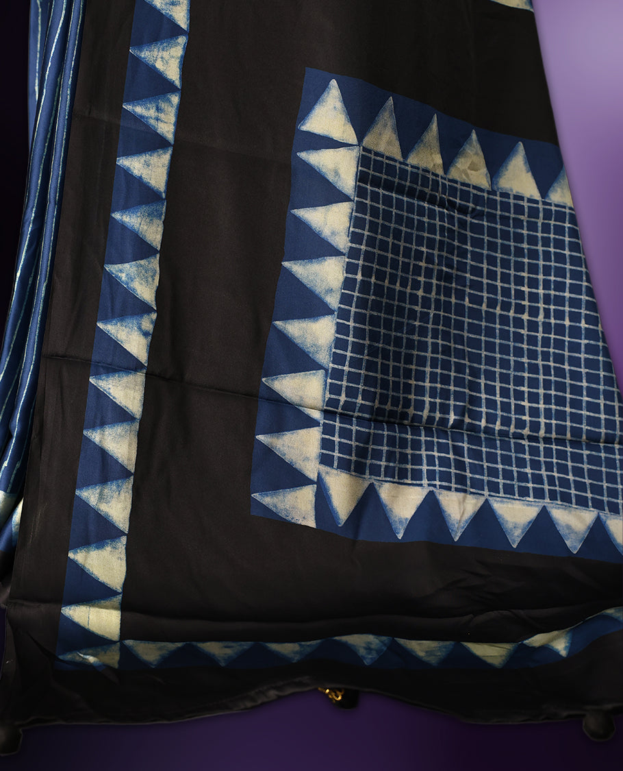 Blue colour saree featuring fine striped patterns across the body, accentuated with bold triangular designs along the border, and a contemporary pallu with geometric detailing, paired with a matching blouse.
