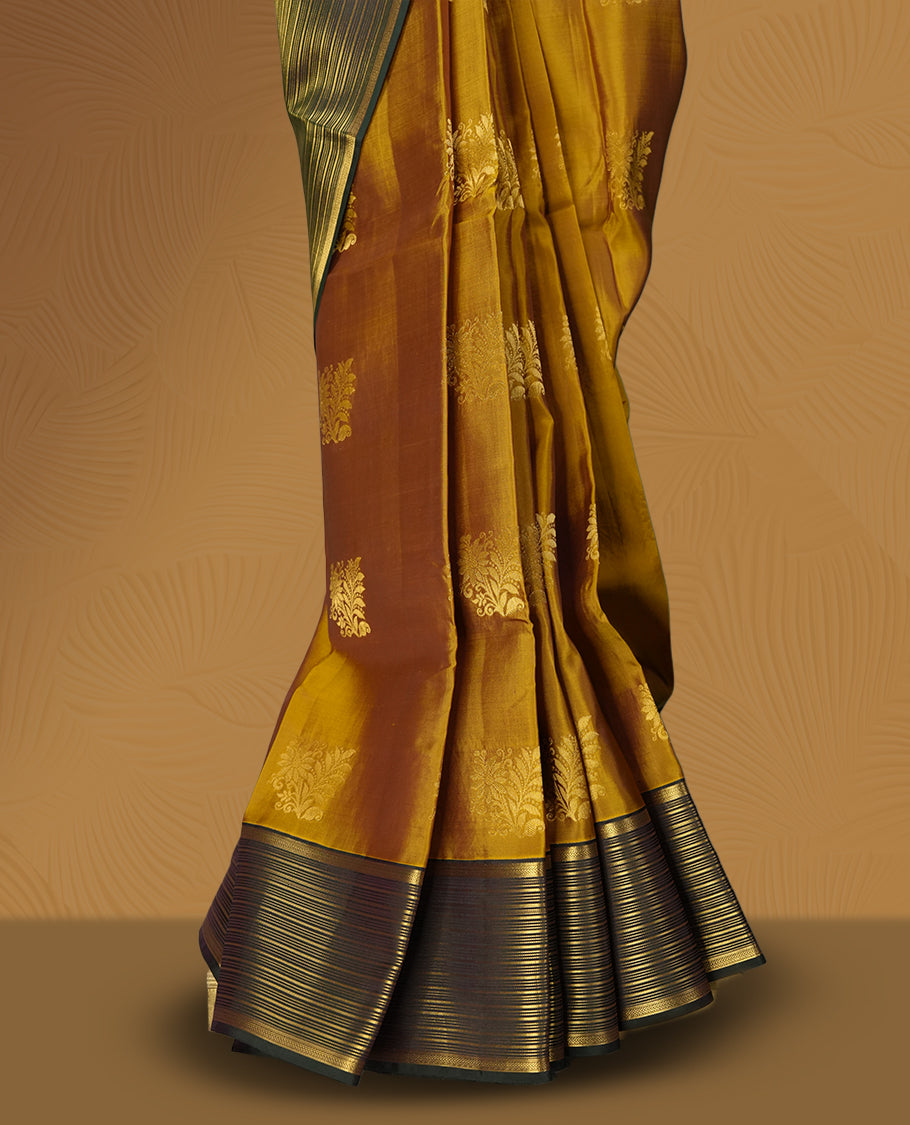 Mustard yellow colour soft silk saree with elegant golden zari motifs, paired with a contrasting dark green border adorned with fine zari stripes & Comes with a matching blouse.