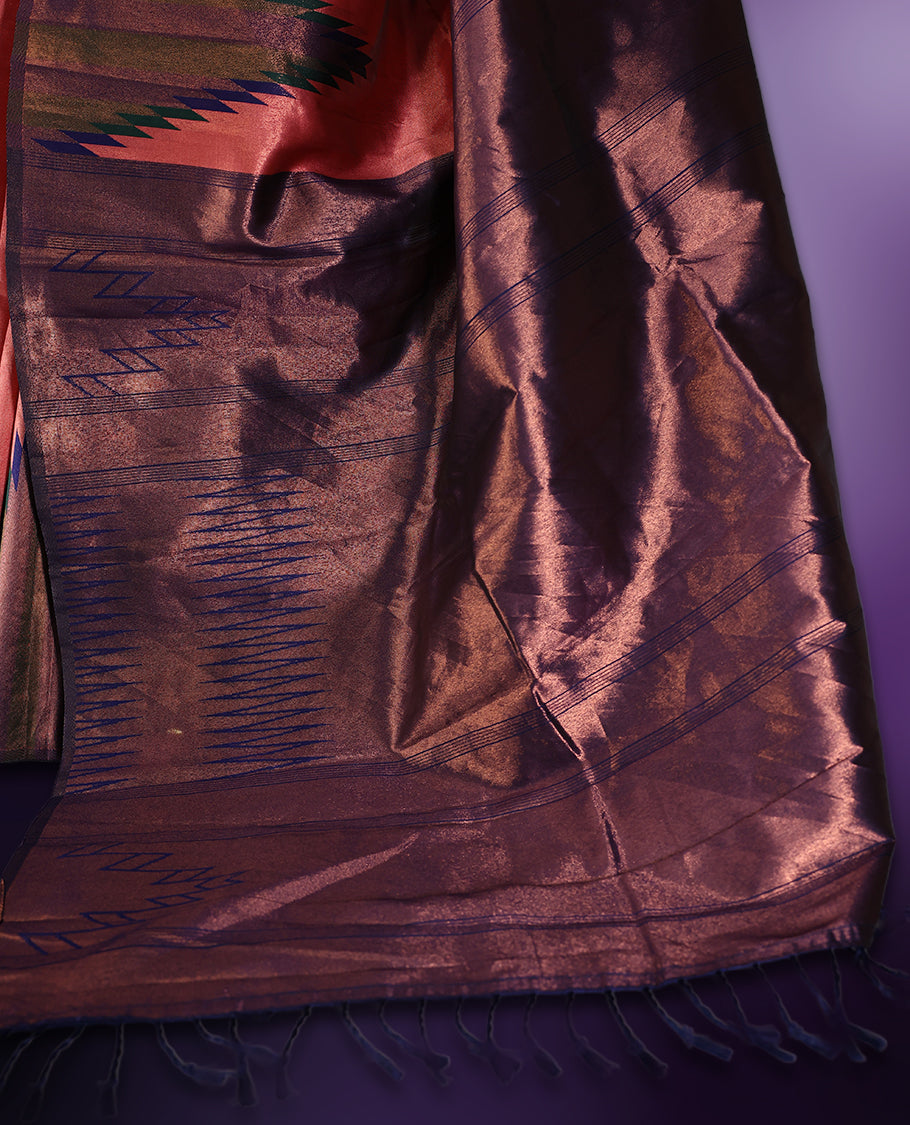 Peach pink saree highlighted with bold black and navy zigzag motifs along the border, complemented by a deep maroon blue pallu with a subtle sheen. Paired with a coordinated blouse piece.