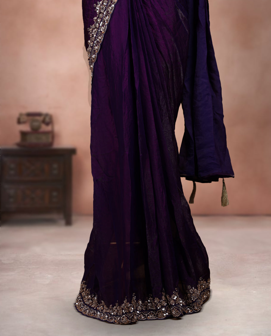 Elegant deep purple ready to wear saree adorned with rich silver zari and bead embroidery along the border and pallu, paired with a heavily embellished matching blouse for a grand festive look.