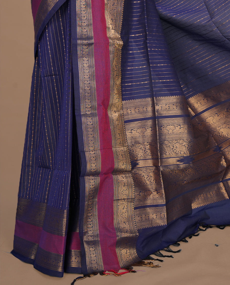 Navy blue colour chettinad cotton saree featuring gold zari stripes on body, complemented by magenta with gold zari border, paired with matching blouse piece.