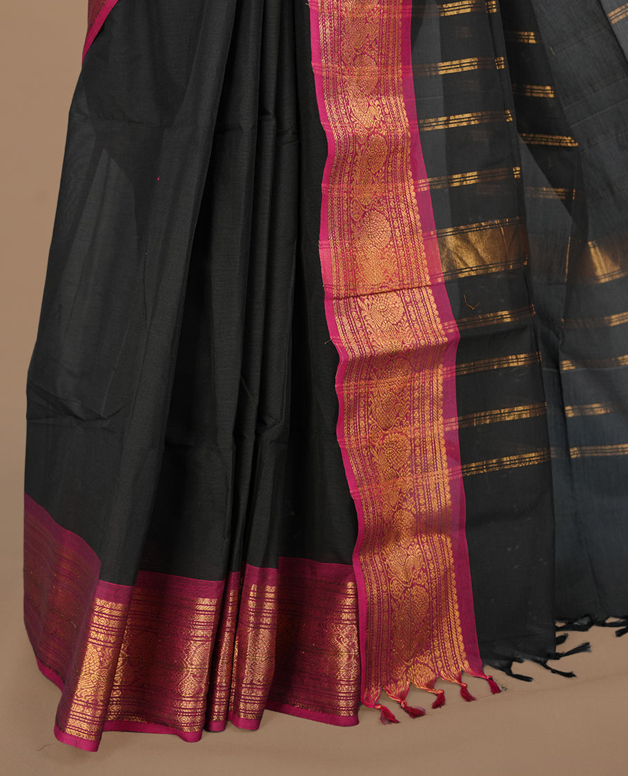 Black colour chettinad cotton saree featuring elegant plain body, complemented by contrast magenta colour with gold zari border, paired with matching blouse piece.