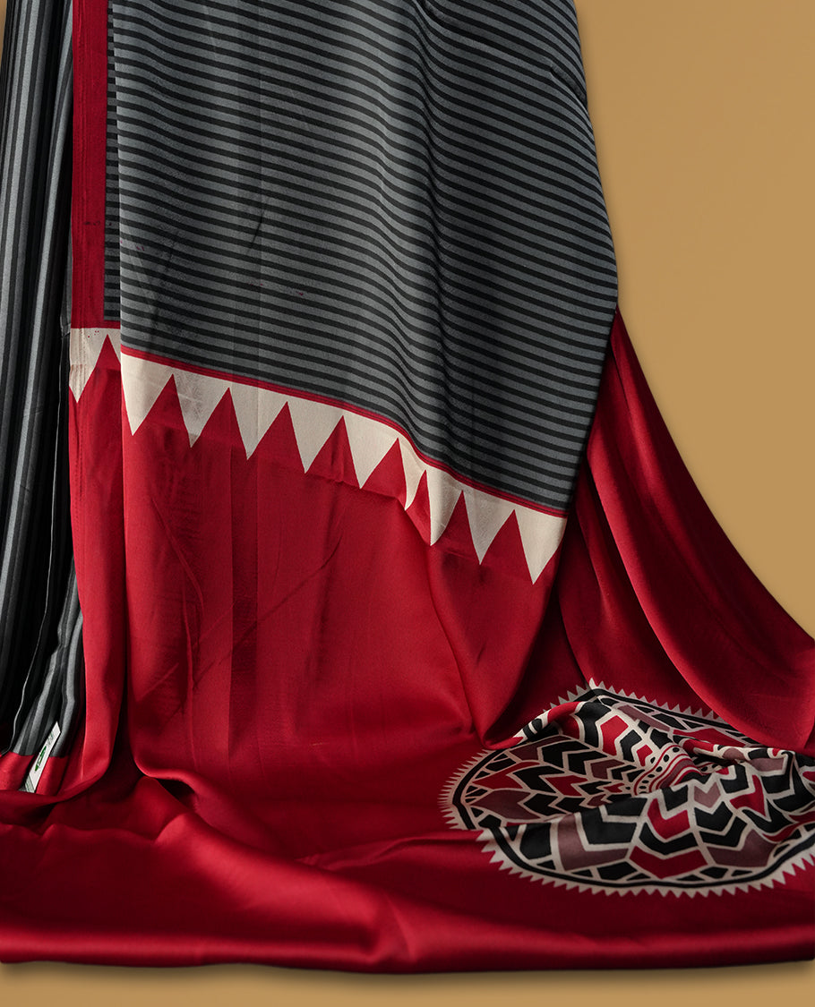 Black colour striped saree highlighted with a bold maroon border, featuring a striking pallu adorned with off white triangular patterns and intricate mandala style embroidery & Paired with a matching blouse.