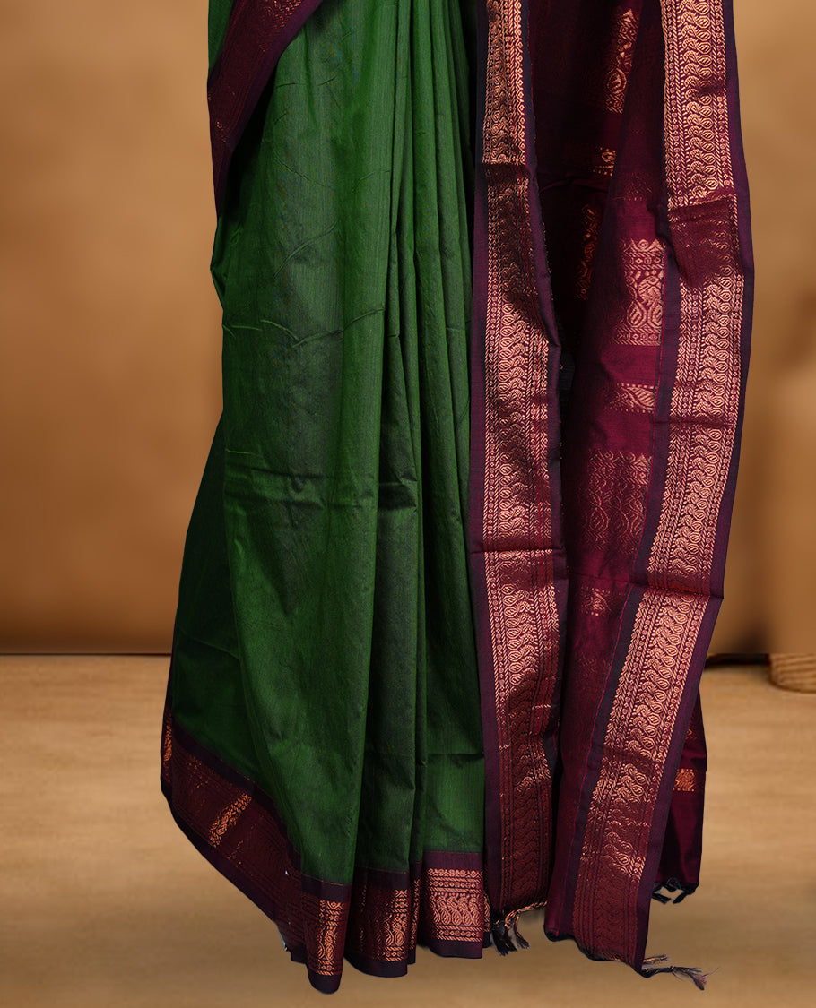 Green colour Kalyani cotton saree featuring a plain elegant body, complemented by a rich maroon zari border and traditional woven pallu, paired with a matching blouse.