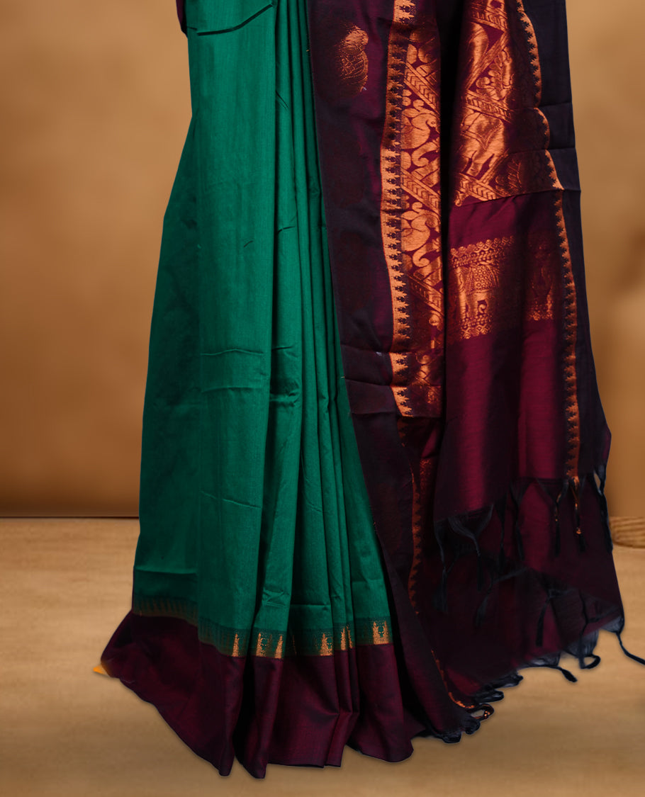 Dark Green colour mixed Kalyani cotton saree with zari motifs on the body, maroon zari border and traditional elephant motif pallu, paired with a matching blouse.