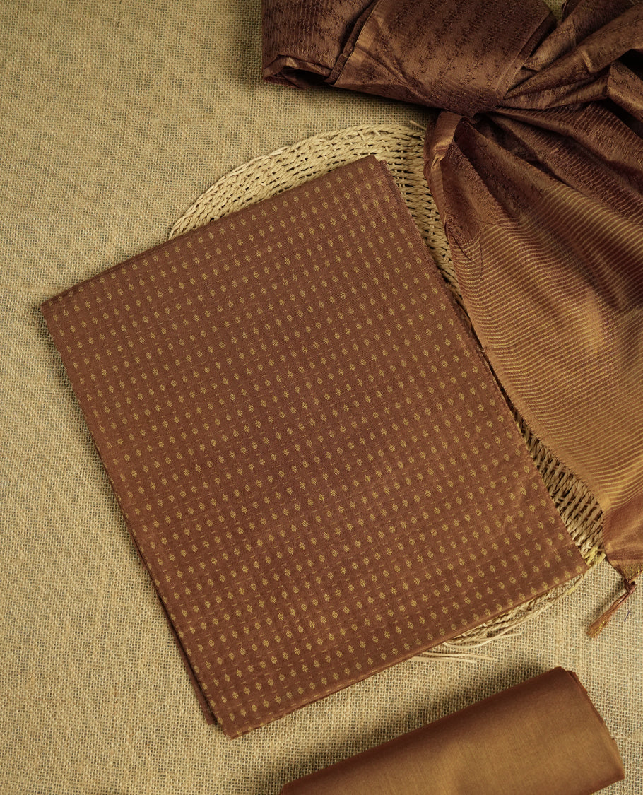 Pastel brown colour tussar suit material adorned with intricate woven patterns and subtle motifs, exuding ethnic elegance & Paired with a beautifully bordered dupatta and a matching plain bottom.