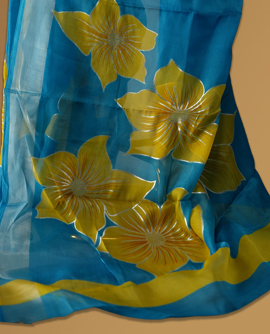 Sky blue colour saree with vibrant yellow floral prints and a soft striped border & Includes matching blouse piece.