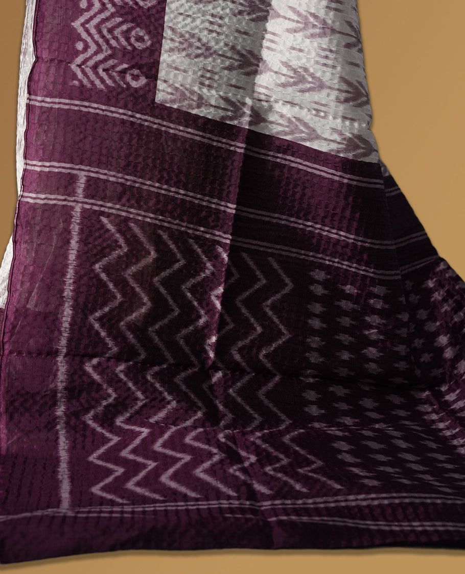 Classic off white colour saree adorned with intricate grape colour tribal motifs and rich woven patterns on the pallu and border & Paired with matching blouse.