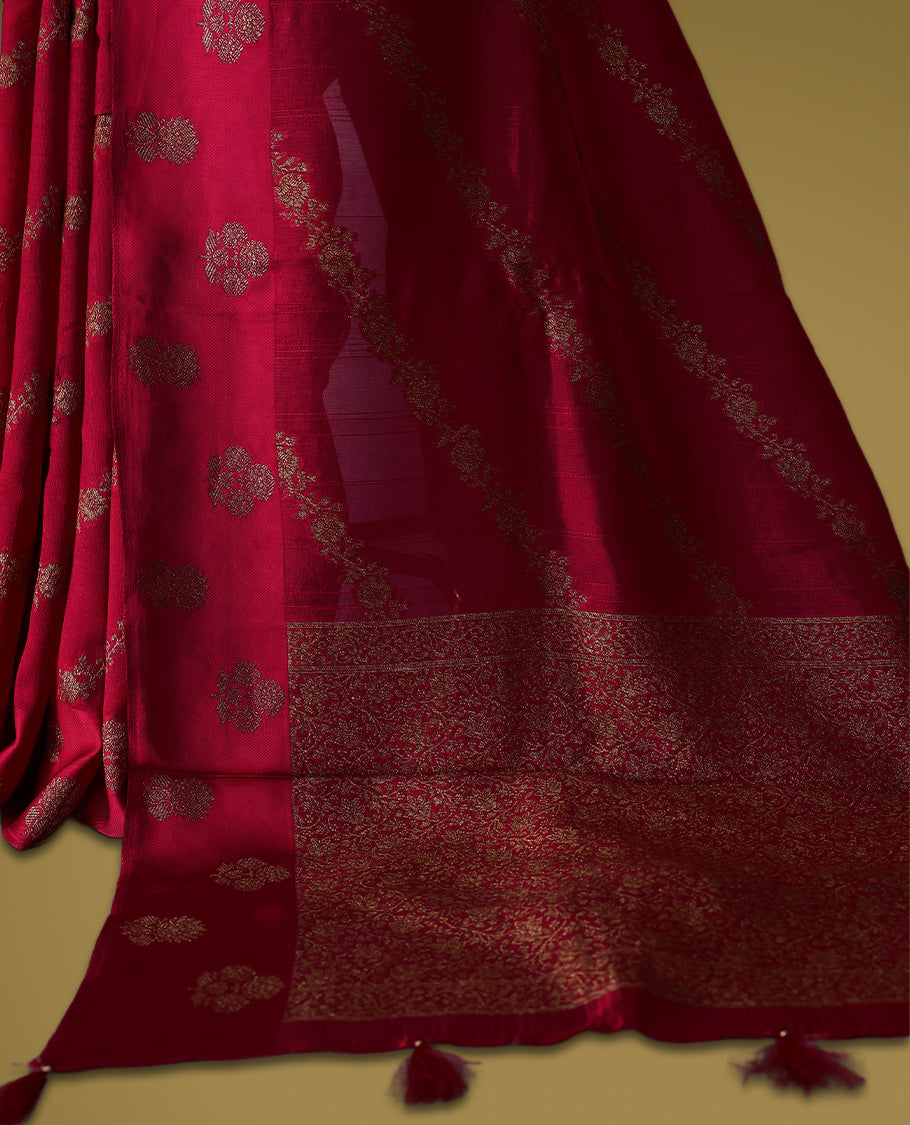 Rani pink semi Banaras tussar saree adorned with golden floral motifs in diagonal patterns across the body and a beautifully woven zari border, finished with a rich golden pallu, paired with a matching blouse.