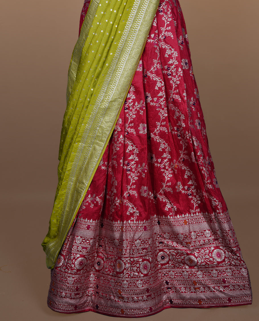 Red colour semi banaras semi stitched dhavani set featuring gold zari floral kodi motifs and traditional border, unstitched matching blouse piece and contrast Olive colour Duptta with silver zari border border.