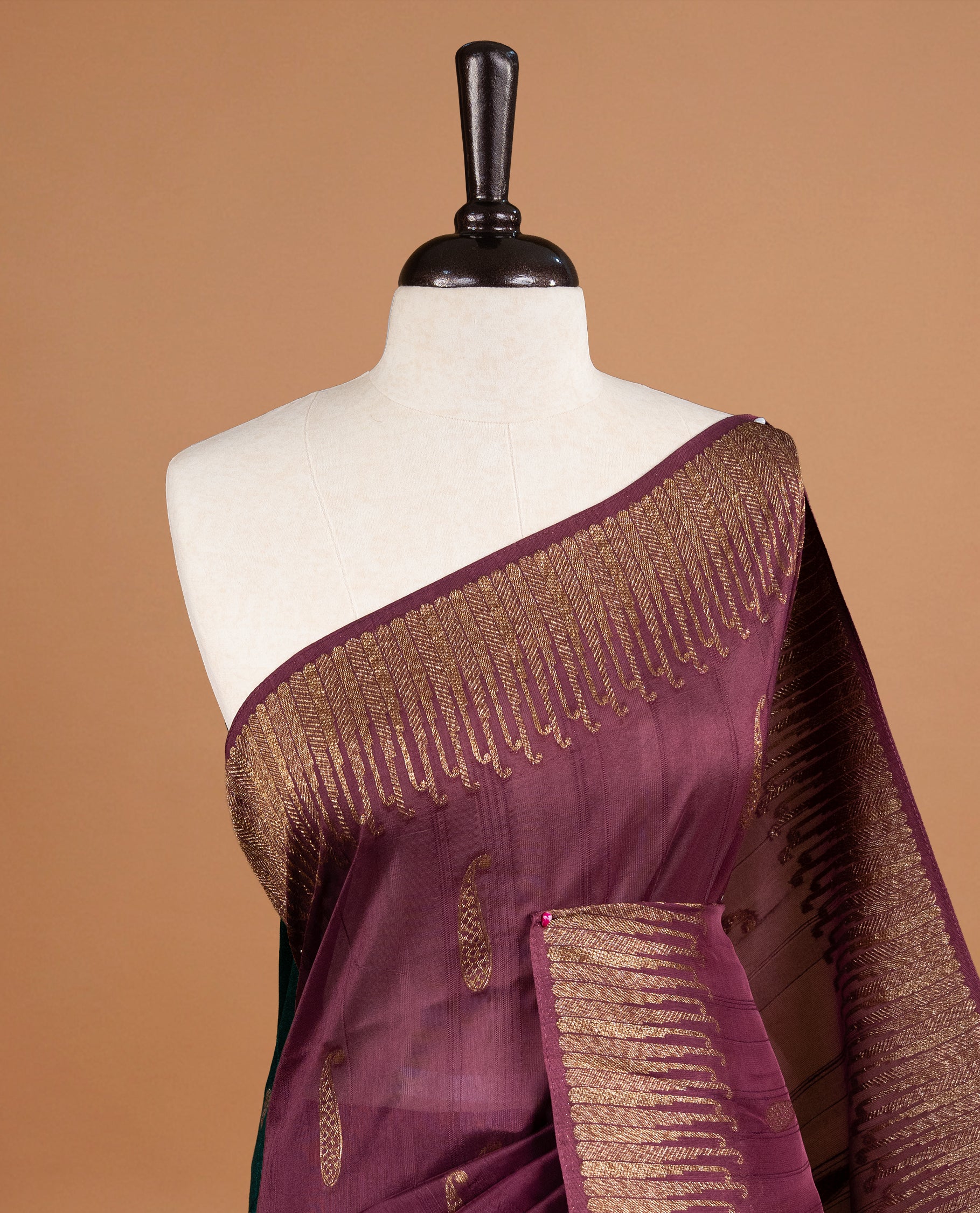 Burgundy colour Semi Banaras Tussar Georgette Featuring Gold zari Leaf pattern on body, Finished with Gold zari border and paired with matching blouse piece.