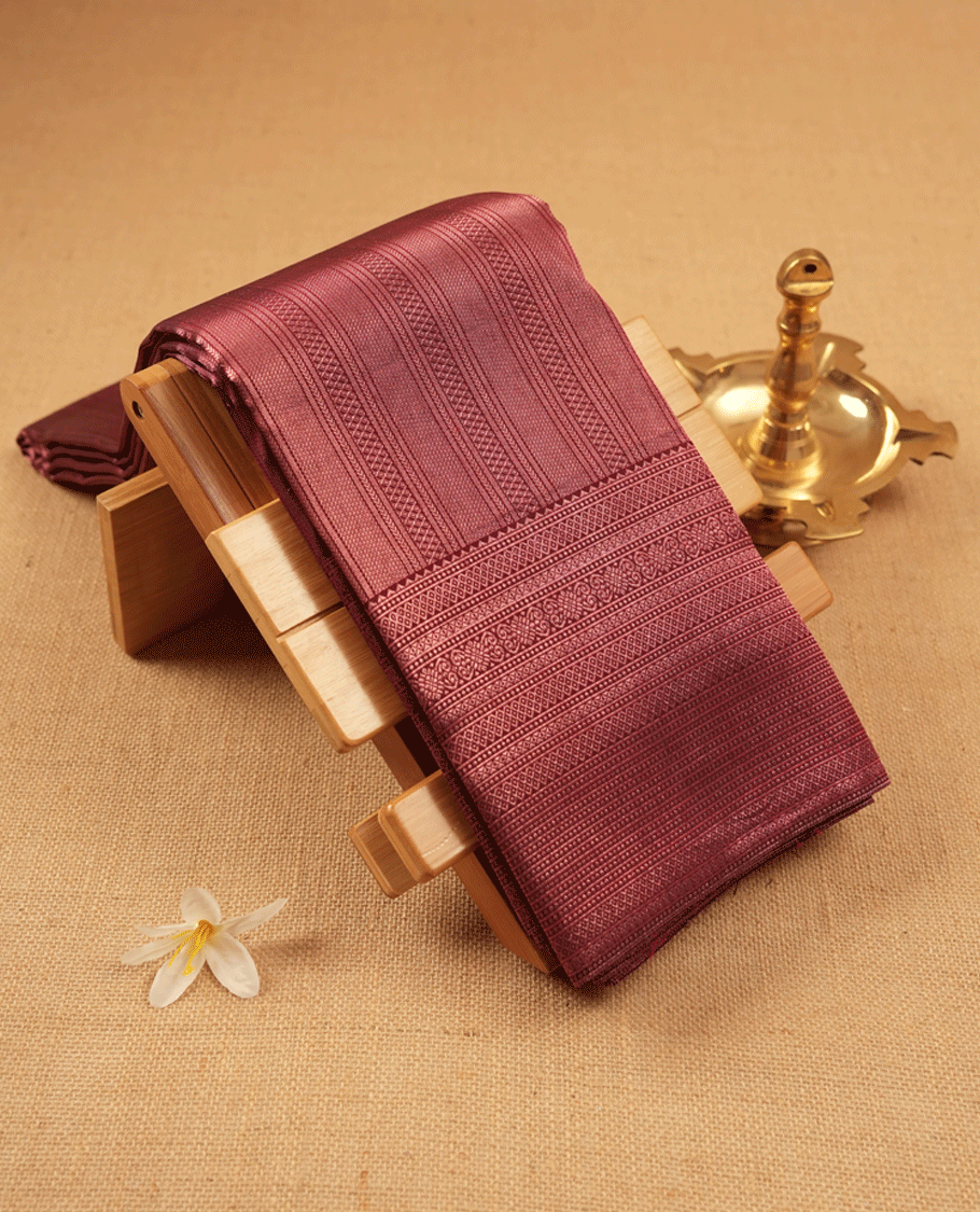 Maroon Colour Manthrakodi saree featuring an antique zari brocade body, complemented by a traditional Jada Naagam brocade border and a matching brocade blouse.