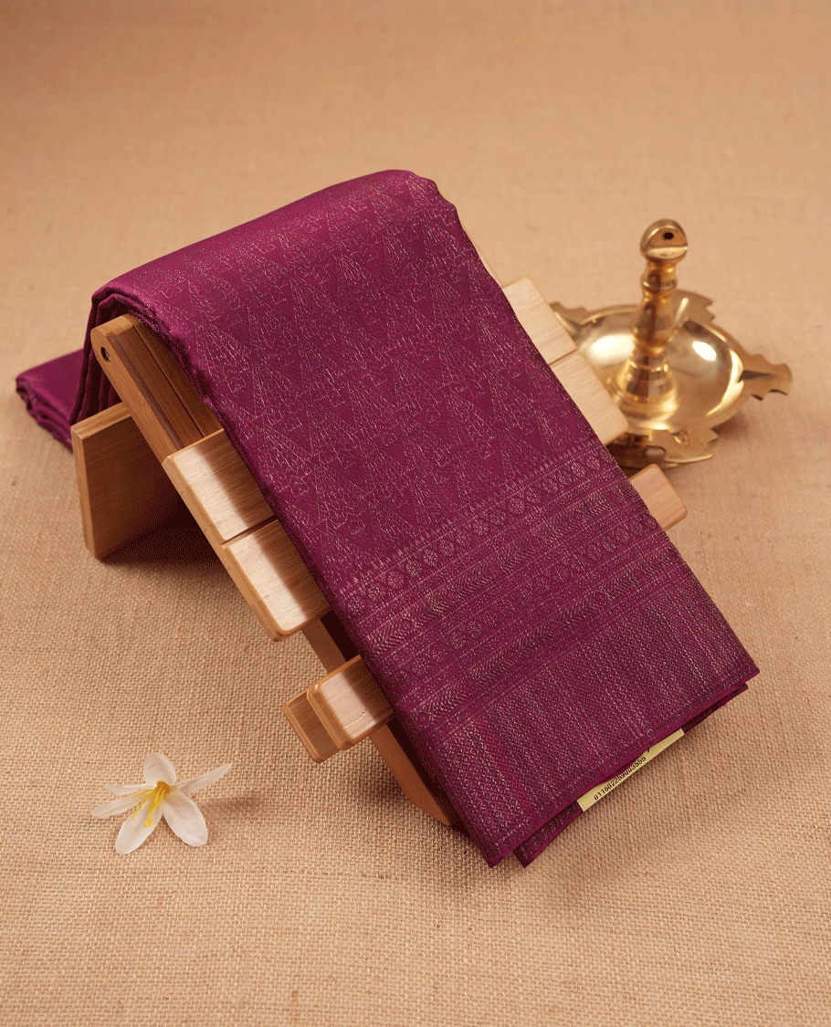 Grape coloured Manthrakodi saree featuring a multicoloured zari jacquard body, complemented by a self coloured turning Banarasi border and a matching self coloured blouse.
