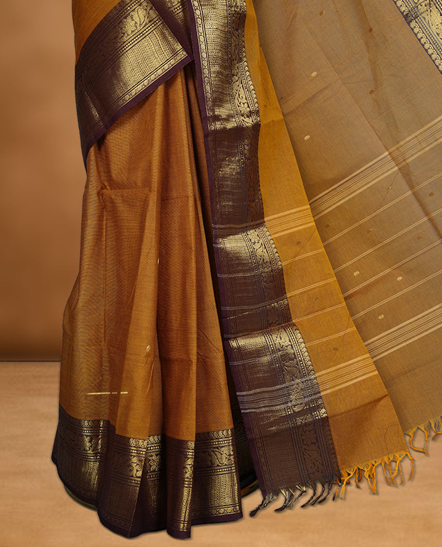 Mustard colour chettinad cotton saree featuring gold zari colour motifs on body, contrast purple colour border with gold zari border, pallu and paired with matching blouse.