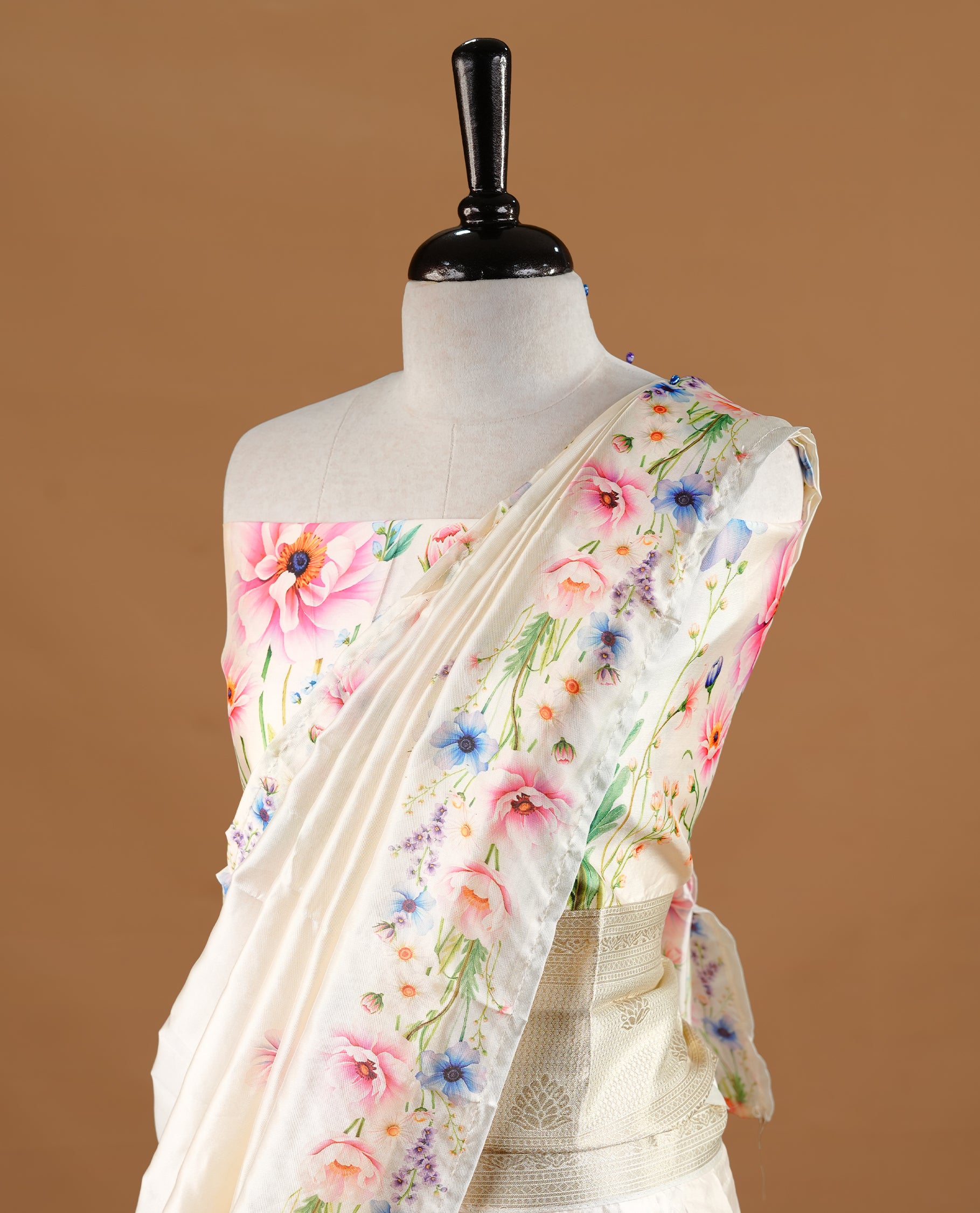 Off white colour semi stitched half saree featuring elegant pink colour floral prints, paired with a cream with traditonal zari border and matching printed dupatta ,paired with matching blouse piece.
