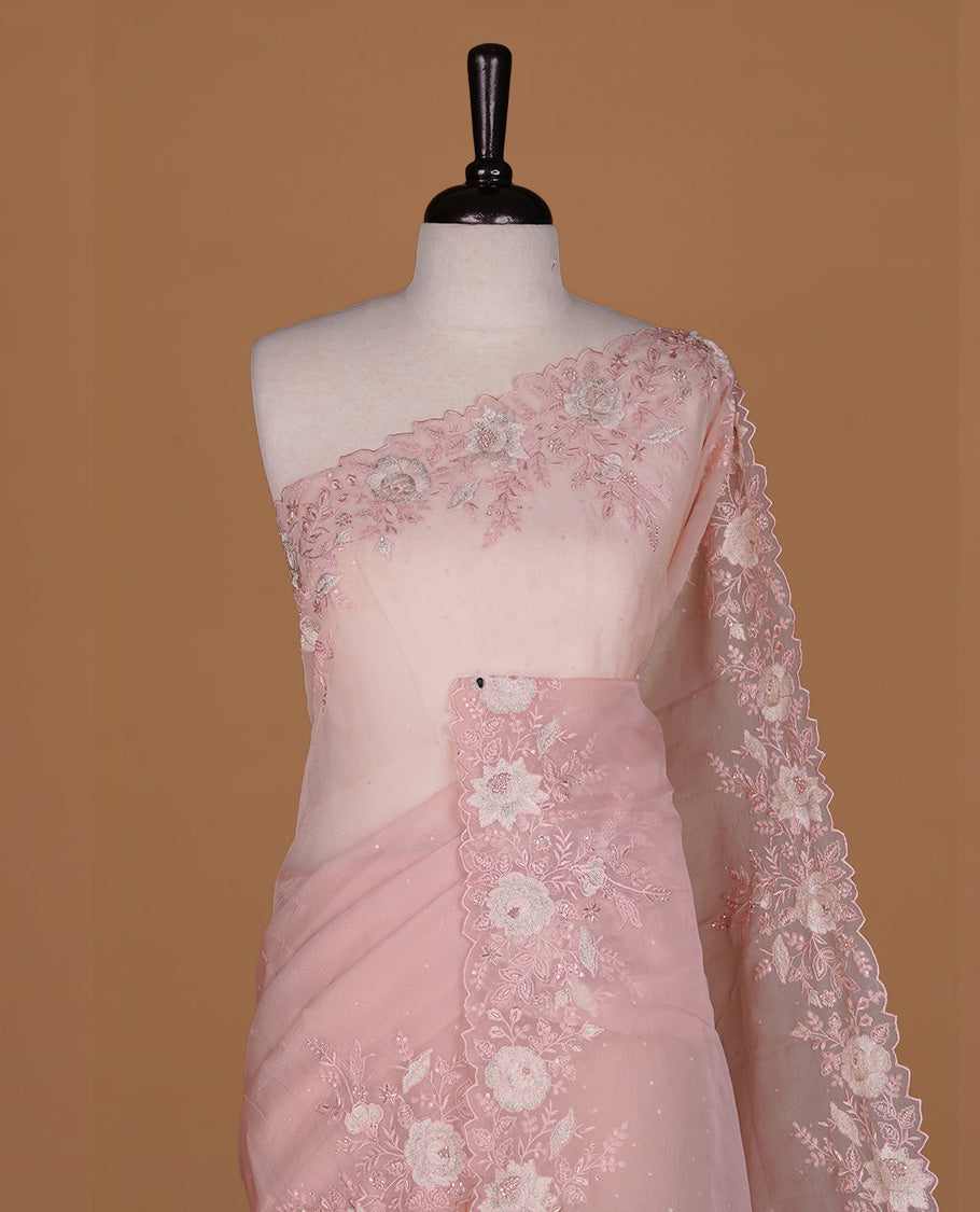 Pinkish beige colour organza saree featuring thread with cut beats & sequins floral pattern on body, highlighting scalp border, paired with matching blouse piece.