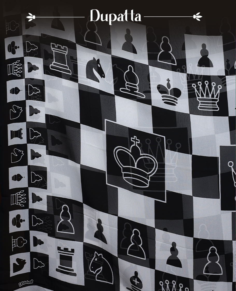 Black & white churidar set featuring a crepe top with chessboard and character prints, paired with a plain santoon bottom and a georgette dupatta adorned with chess coin prints.