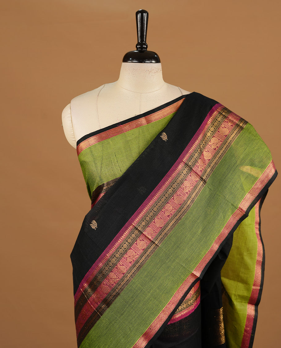 Black colour chettinad cotton saree featuring gold zari motifs on body, complemented by magenta & green colour with zari border, paired with matching blouse piece.