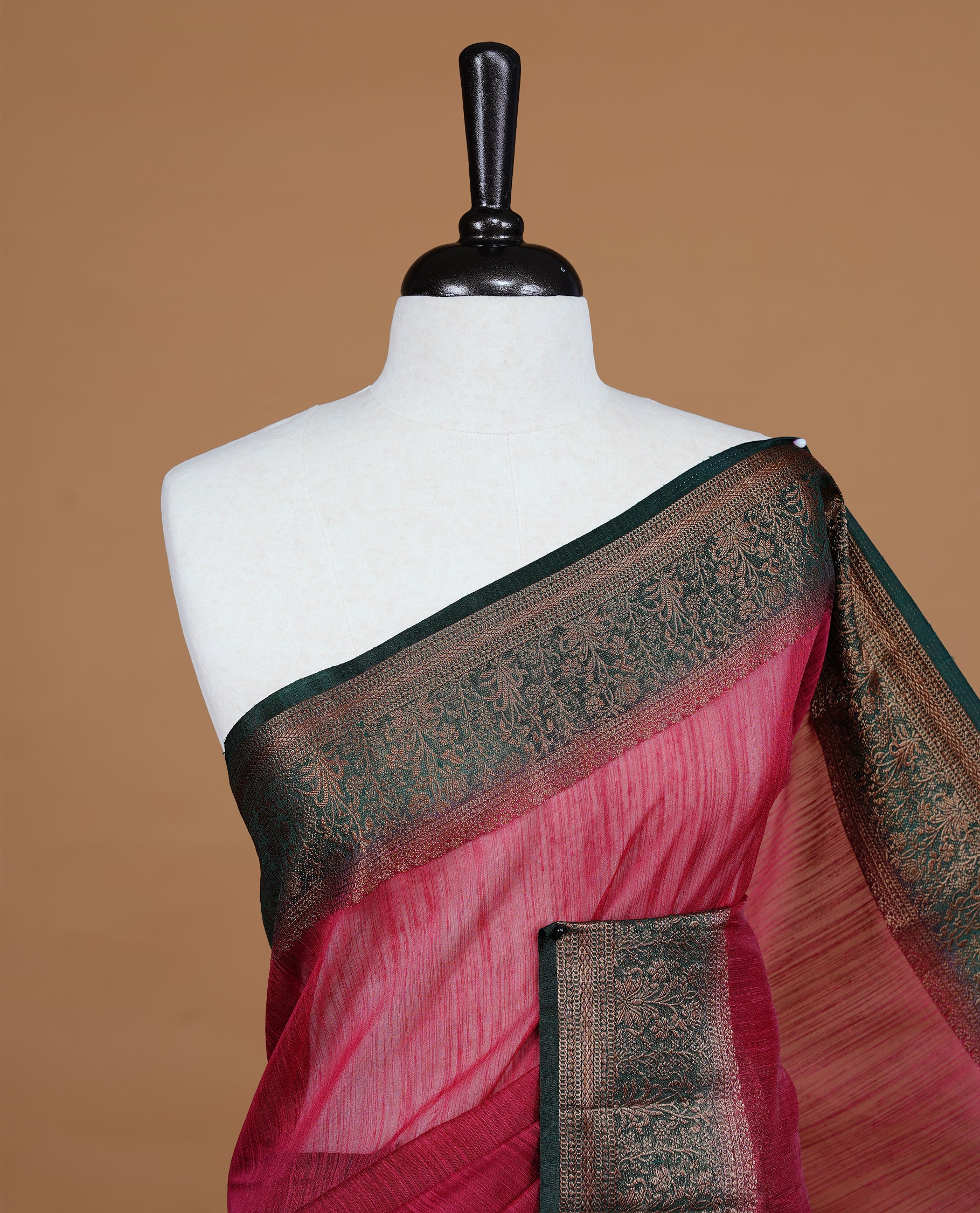 Maroon colour Semi linen saree featuring Elegant plain body, complemented by contrast Green colour With Antique zari border, paired with matching blouse piece.