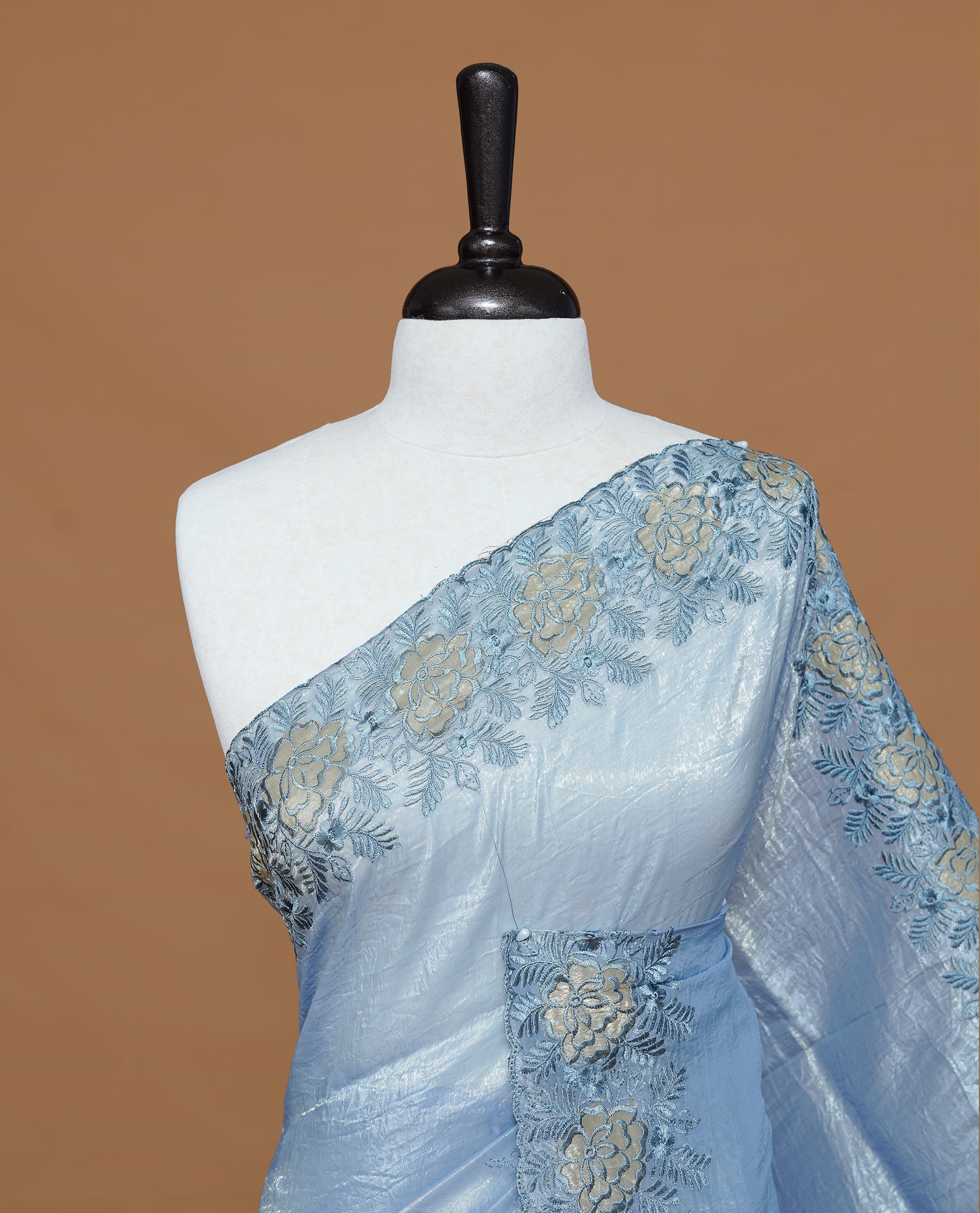 Pastel Blue colour Crush Organza Featuring Plain body, Enrich with Floral thread pattern & scalp border, paired with matching blouse piece.