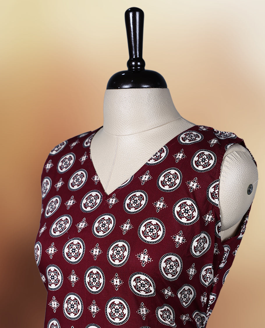 Dark maroon colour sleeveless nightwear with intricate beige and black floral prints in circular patterns, Designed with a V neckline, this kurthi comes with matching fabric sleeves included for a versatile look.