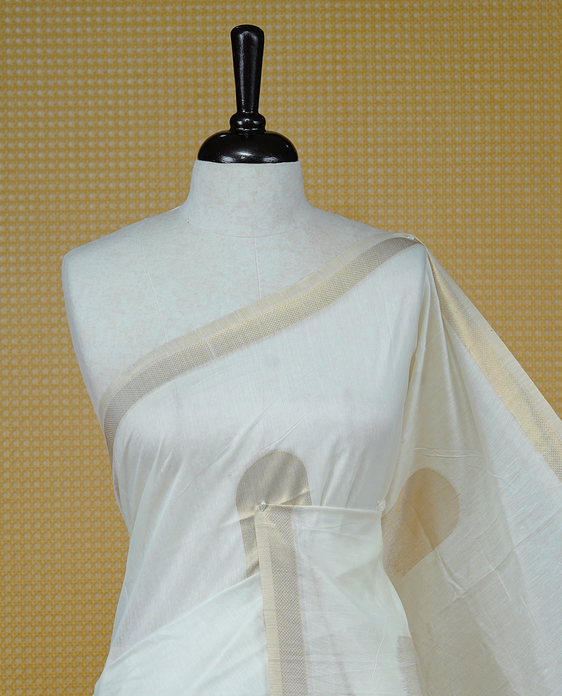 Cream Colour Organza Kerala Saree Featuring Gold Zari Buttas On The Body, Enhanced By A Gold Zari Border & Geometric Design Pallu, Paired With A Matching Blouse Piece.