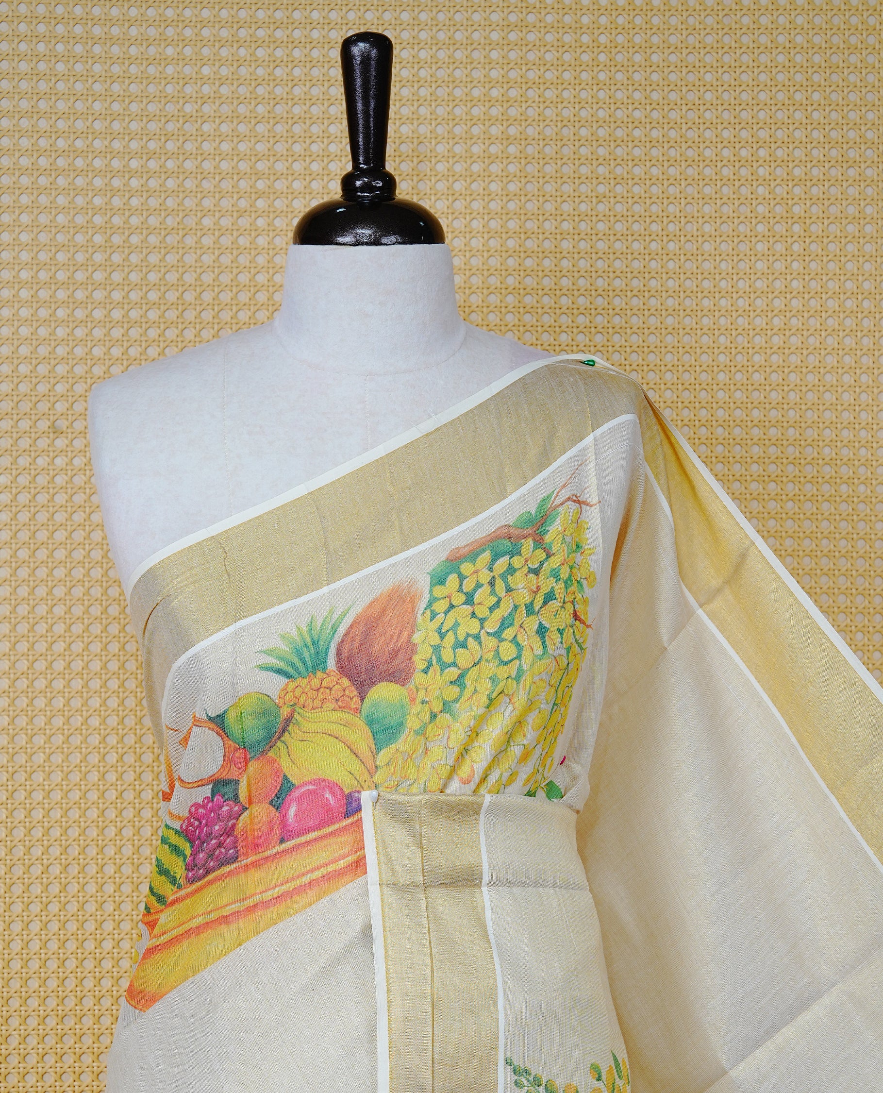 Cream Colour Tissue Kerala Saree Featuring A Digital Vishu Theme At Body & Pallu, Beautifully Enhanced With A Classic Gold Zari Border And Green & Red Tassels Paired With A Matching Blouse Piece.