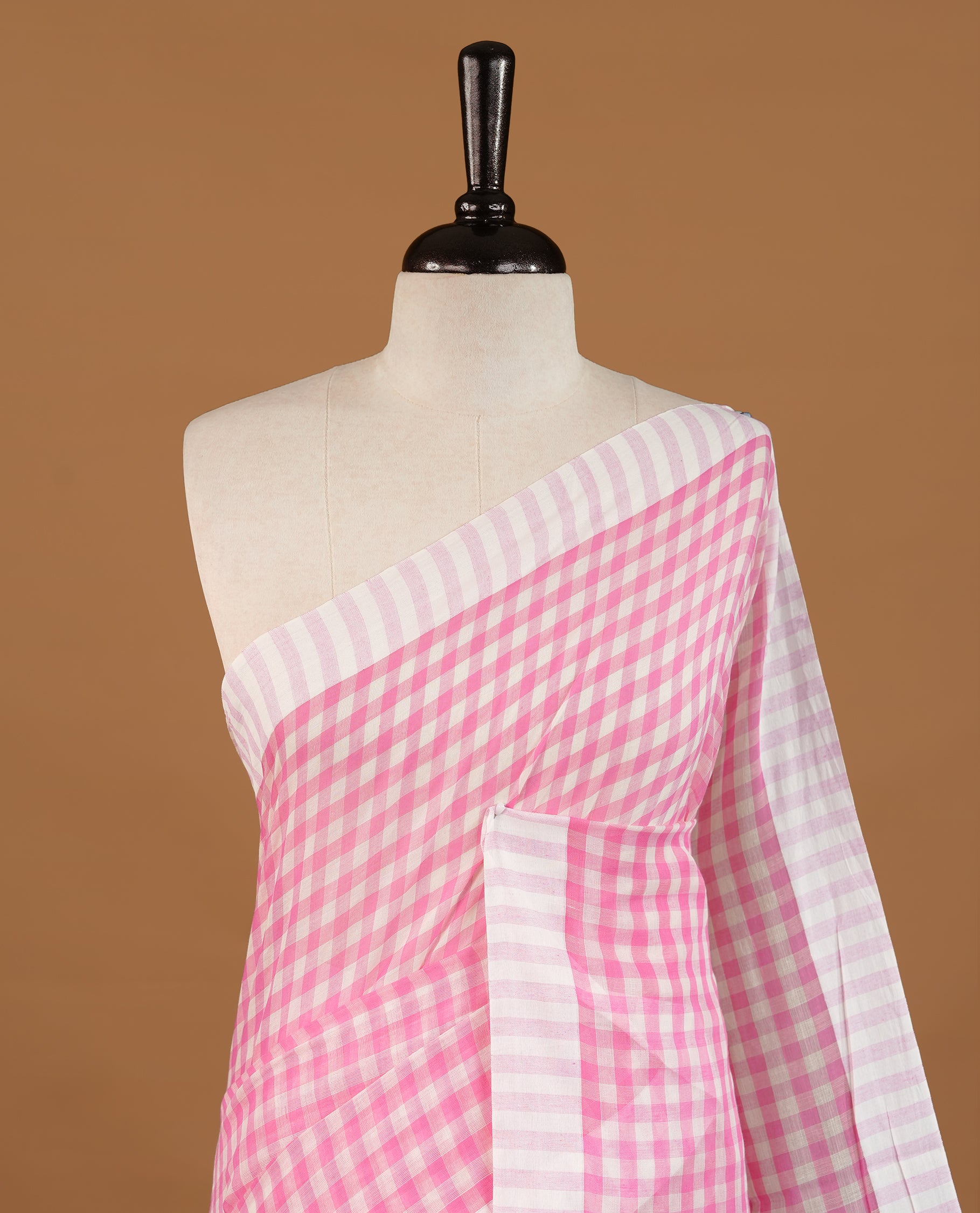 Pink and White colour Mul Cotton saree featuring a classic Big check pattern on the body, accented with tassels for added charm. Comes without a blouse piece.