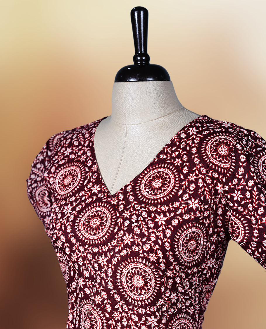 Dark maroon colour nightwear with intricate floral prints in circular patterns in beige colour, Designed with a V neckline, short sleeves, and a flared hemline. Ideal for casual outings, workwear, or ethnic inspired looks.