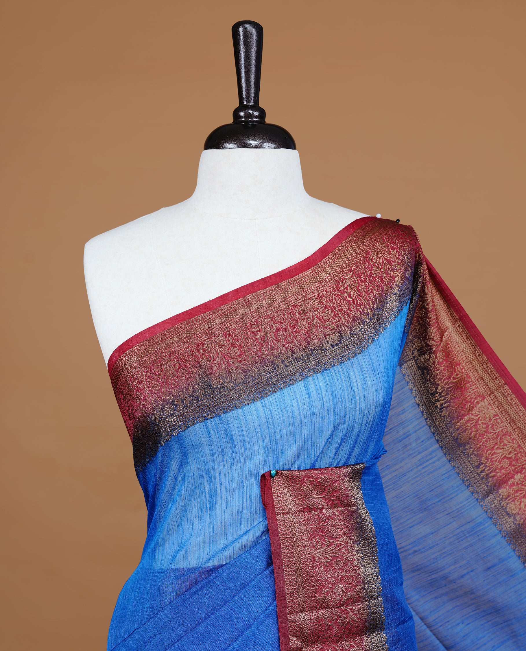 Blue colour Semi linen saree featuring Elegant plain body, complemented by contrast Maroon colour With Antique zari border, paired with matching blouse piece.