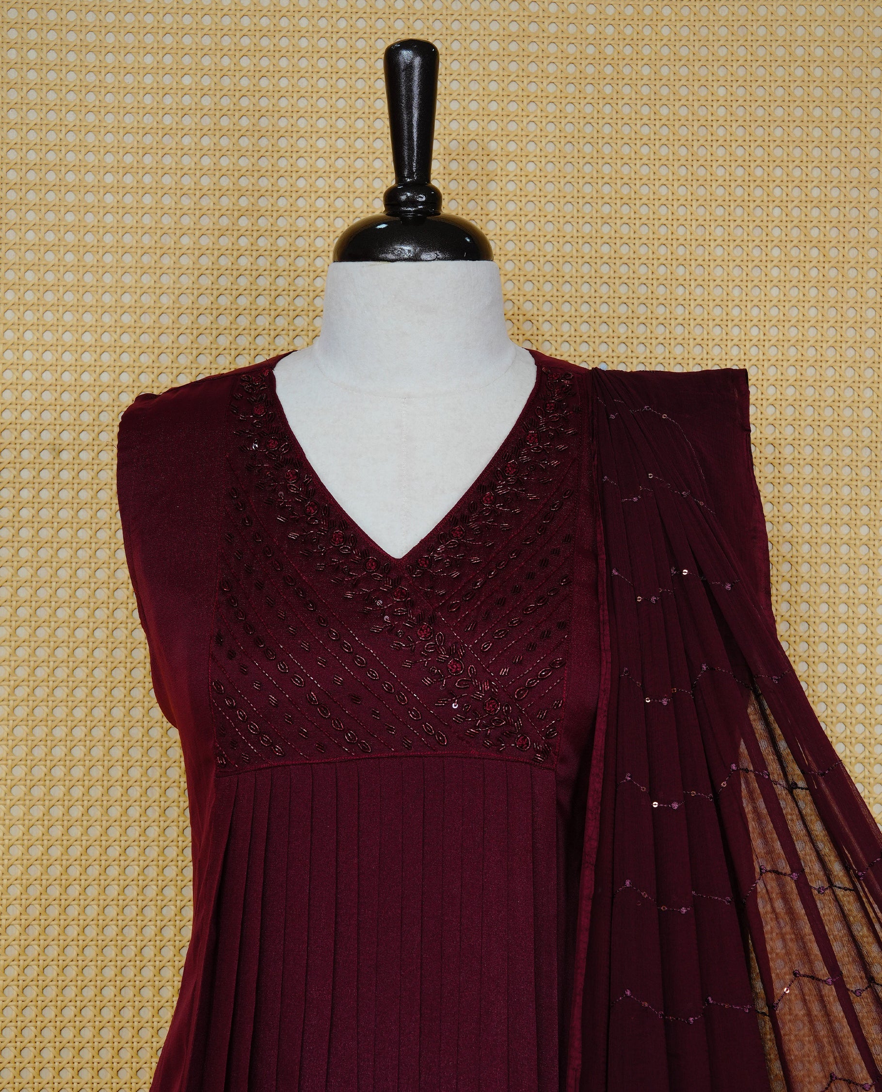 Dark maroon colour churidar set with bead & thread embroidery on the V-neckline, paired with a matching embellished dupatta and solid pants.