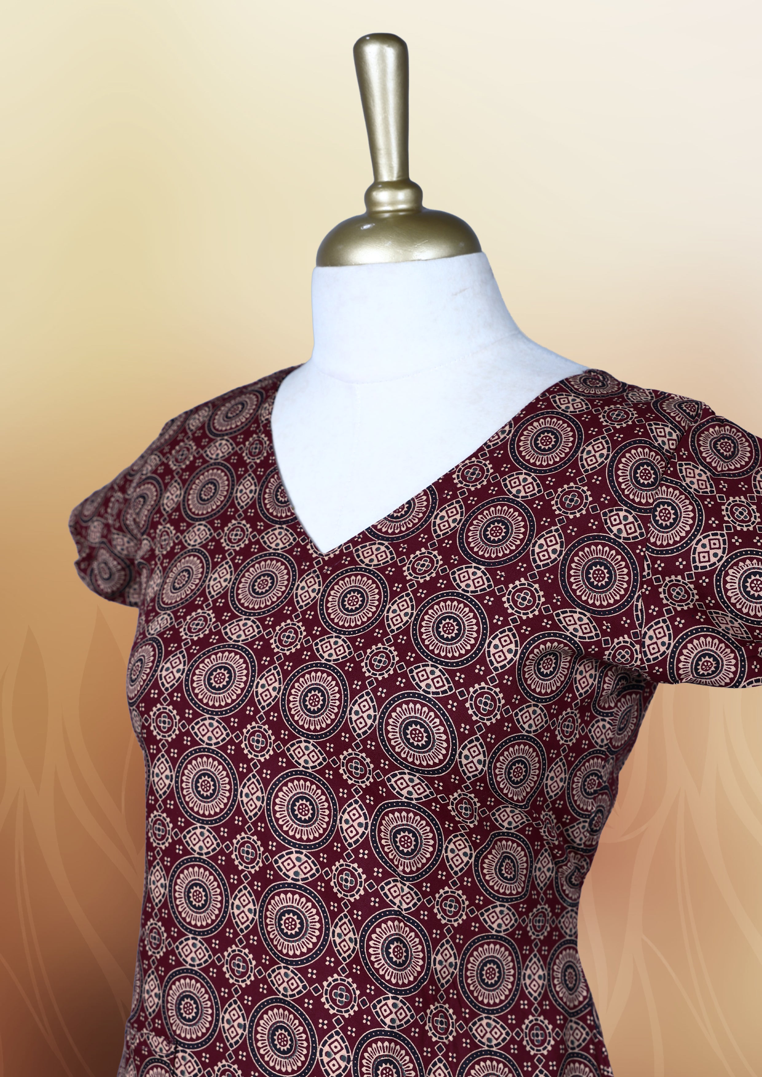 Classy maroon colour nightwear with intricate circular patterns in beige and black, Designed with a V neckline, short sleeves, and a flared hemline. Ideal for casual outings, workwear, or ethnic inspired looks.
