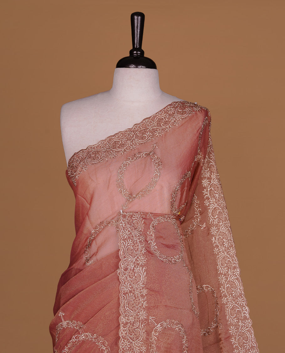 Pinkish orange colour organza saree featuring thread & gold stone pattern on body, highlighting scalp border, paired with Matching blouse piece.