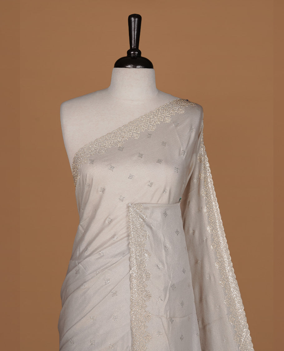 Off white colour organza designer saree featuring Gold stone motifs on body, highlighting light weight stone worked border, paired with matching blouse piece.