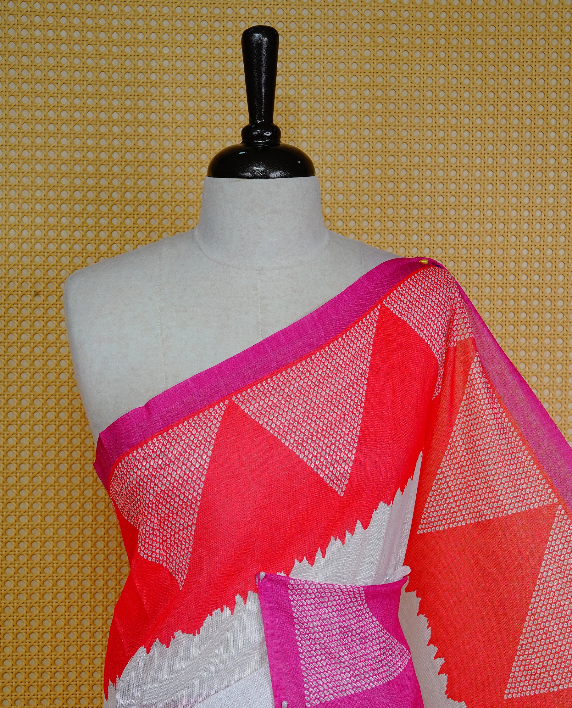 Cream colour semi linen saree featuring Pink Ajrakh pattern print on body, complemented by contrast Red colour with same pattern print Pink border, comes with matching blouse piece.