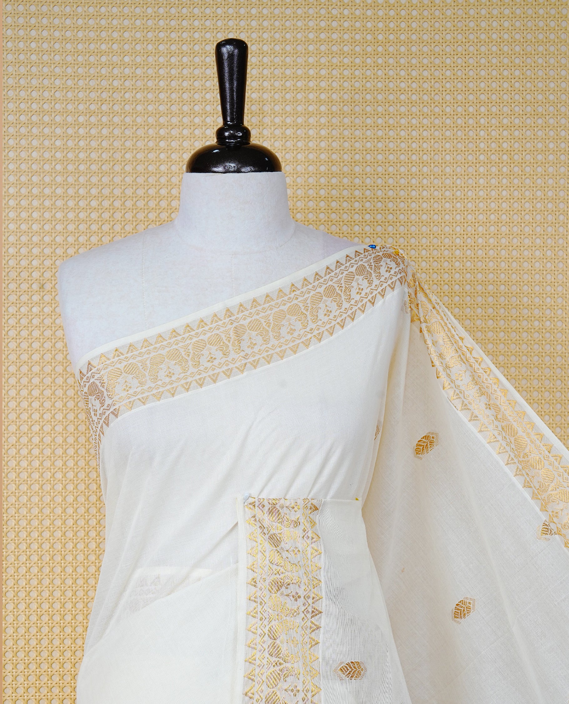 Cream Colour Cotton Kerala Saree Featuring Gold Buttas on the Body, a Classy Gold Zari Border, and a Traditional Blue Colour Lord Krishna Thread work and Gold Zari Pallu, Paired with a Matching Blouse Piece.