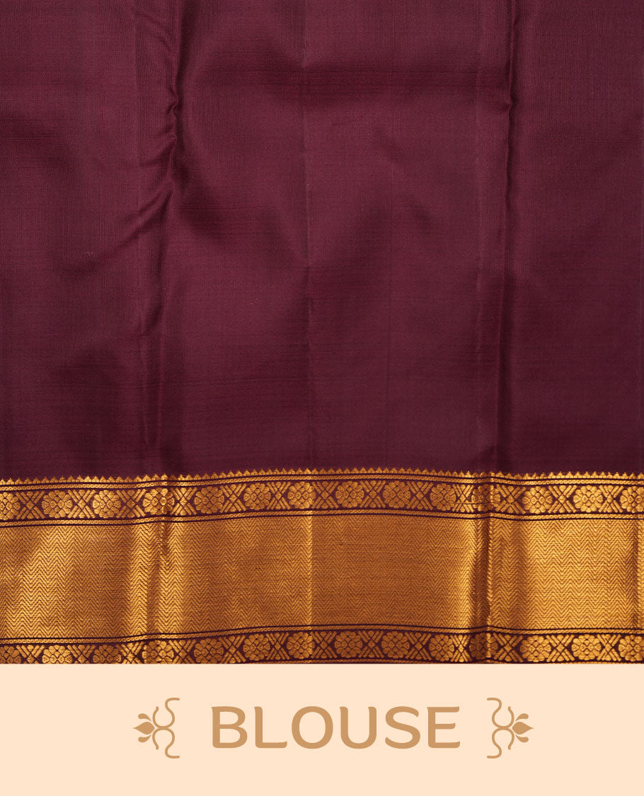 Dark chocolate colour pure traditional Kancheepuram silk saree adorned with elegant peacock and chakra motifs across the body, featuring rich gold zari traditional borders, beautifully paired with a matching blouse piece.