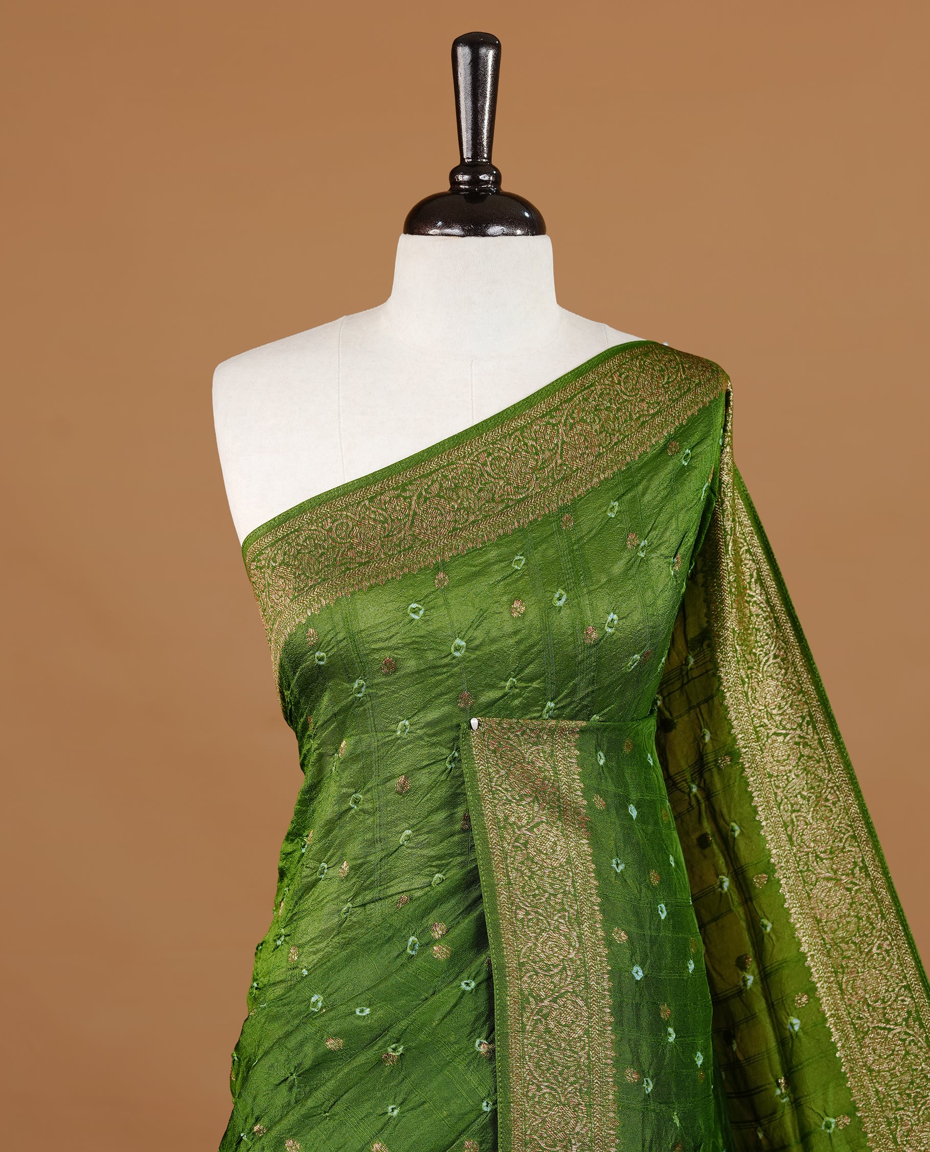 Green colour Banarasi Bandhani silk saree featuring intricate antique zari circle Buttas across the body, complemented by an elegant antique zari border. Comes paired with a matching blouse piece