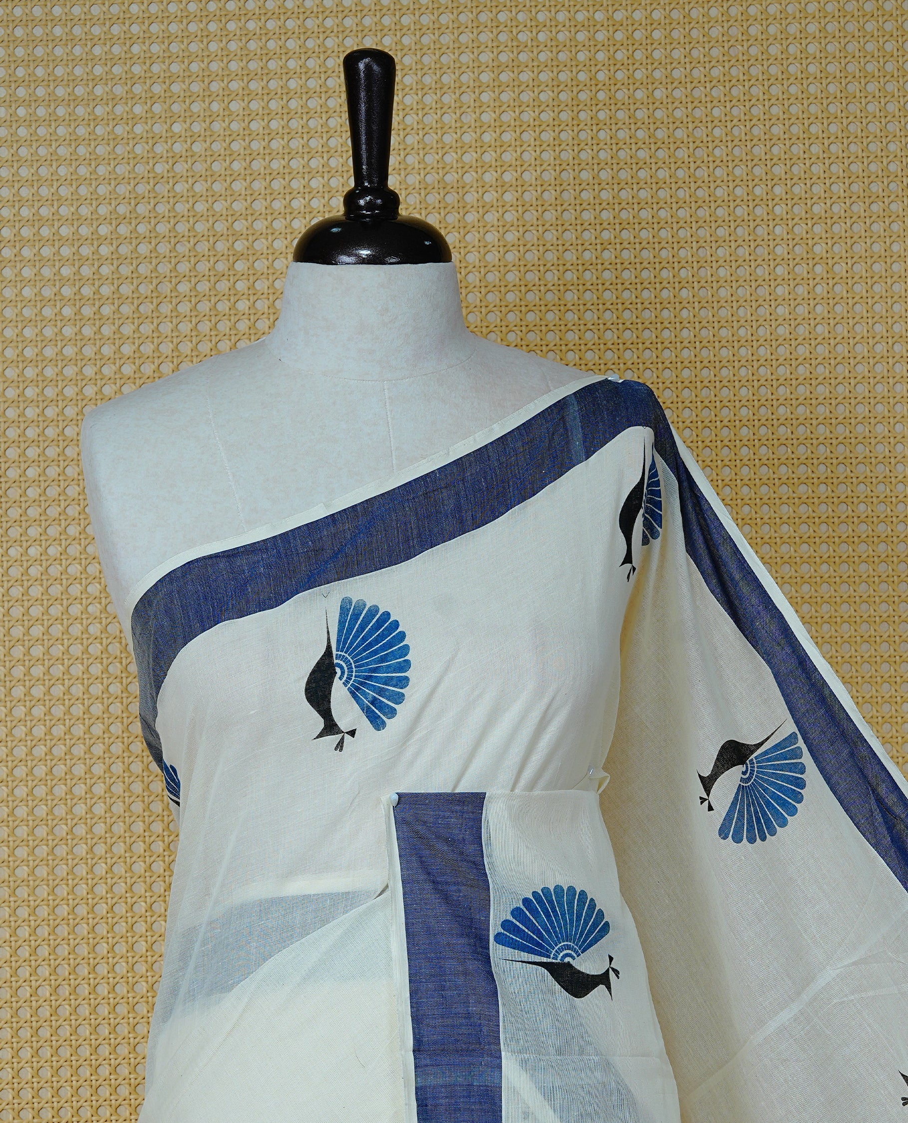 Cream colour Cotton Kerala saree Featuring Classy Plain body for Effortless Elegance, enhancing Navy blue with Peacock Printed border, paired with matching blouse piece.