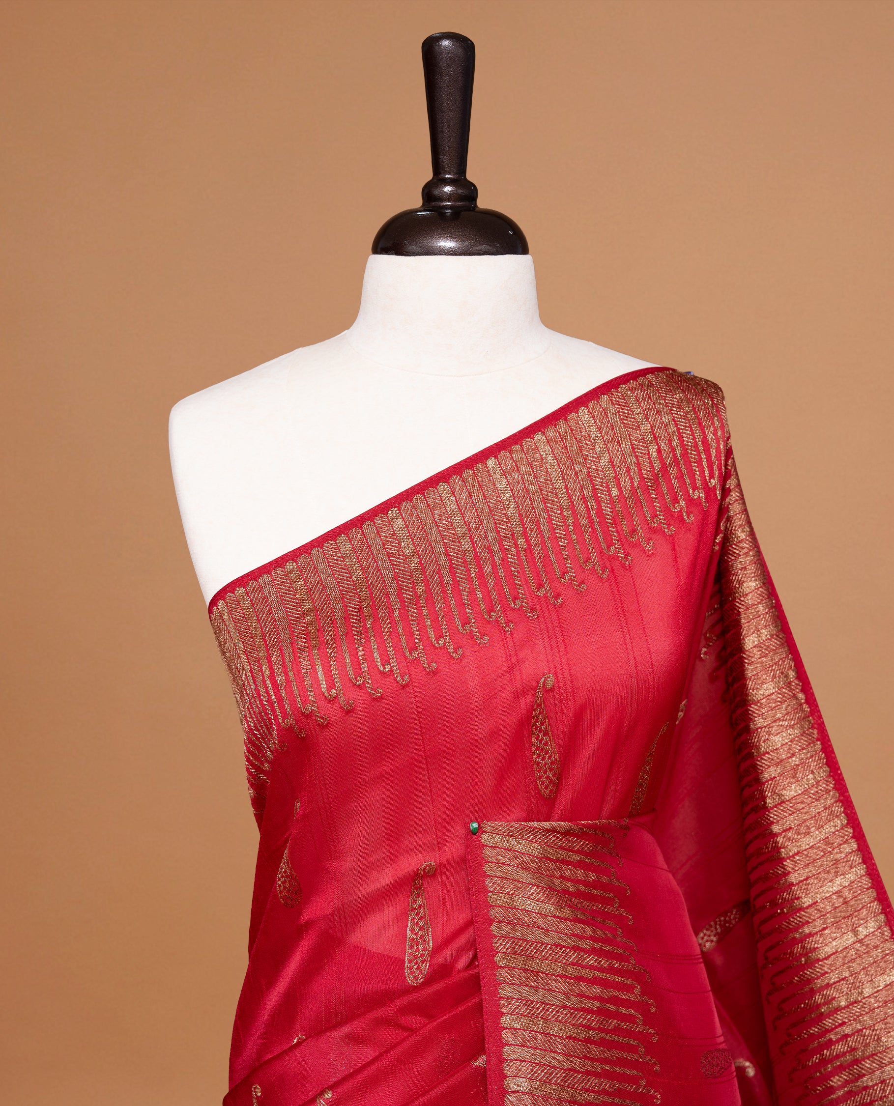 Red colour Semi Banaras Tussar Georgette Featuring Gold zari Leaf pattern on body, Finished with Gold zari border and paired with matching blouse piece.