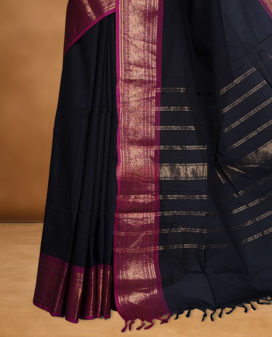 Black colour chettinad cotton saree featuring elegant plain body highlighting contrast magenta colour with gold zari traditional border, pallu and paired with matching blouse piece.