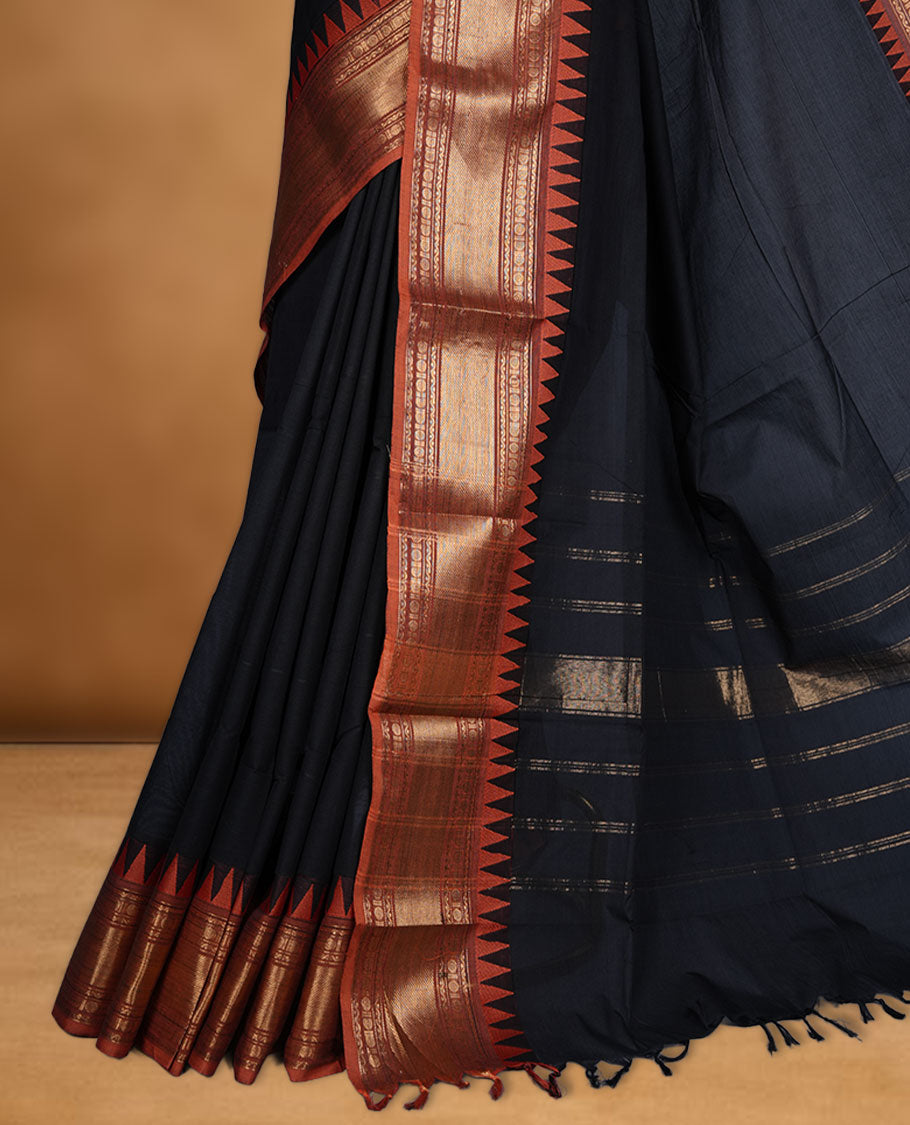 Black colour chettinad cotton saree featuring Elegant plain body highlighting contrast orange colour colour with gold zari traditional border, pallu and paired with matching blouse piece.